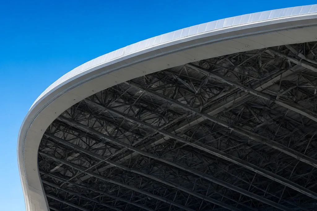 Large stadium roof structure against a clear blue sky